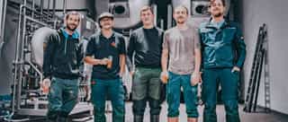 Das Bild zeigt eine Gruppe von Männern, die in einem Raum zusammenstehen.