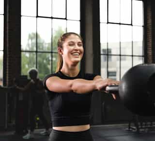 Sportlerin beim Training mit Kugelhantel für den Oberkörper auf der Trainingsanlage von Physiosport Köln.