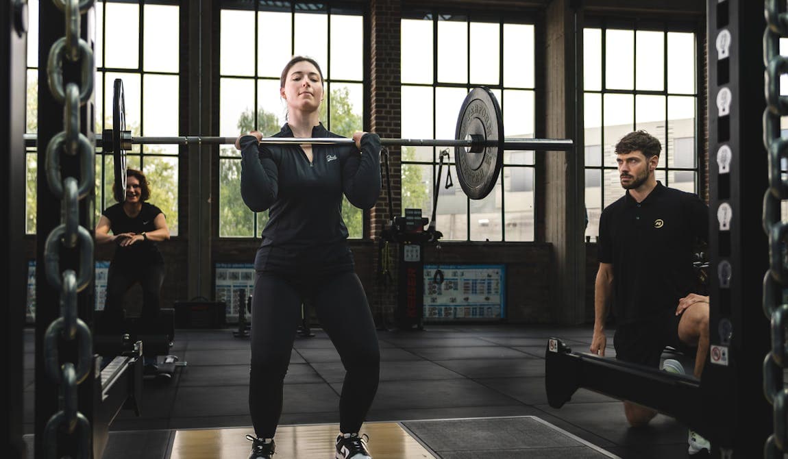 Frau beim Training mit Langhantel bei PhysioSport Köln..