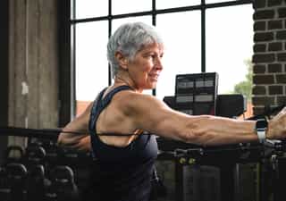 Frau beim Training mit Seilzug für Oberkörper und Fitness.
