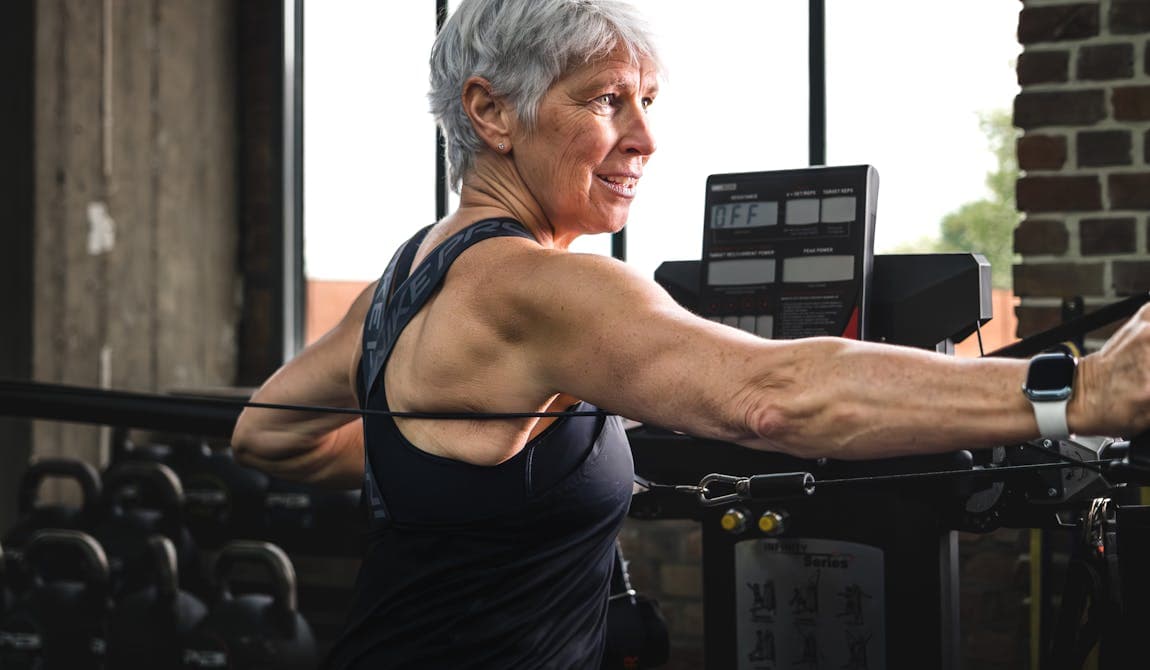 Frau beim Training mit Seilzug für Oberkörper bei PhysioSport Köln.