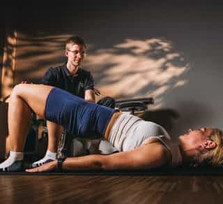 Physiotherapeut von PhysioSport Köln unterstützt eine Behandlung mit Krankengymnastik.