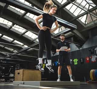 Trainer von Physiosport Köln mit Sportlerin bei Sprunganalyse zur Verbesserung der Sprungtechnik.