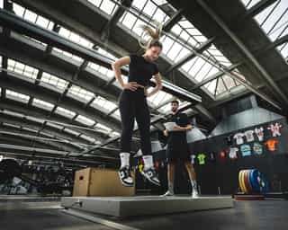 Trainer von Physiosport erläutert Sportlerin Kraftübungen für die Verbesserung der Sprungkraft.