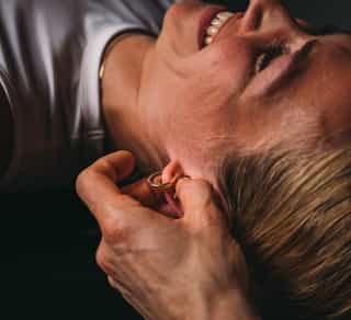 Osteopathische Behandlung am Kopf einer Patientin in der Praxis PhysioSport Köln.