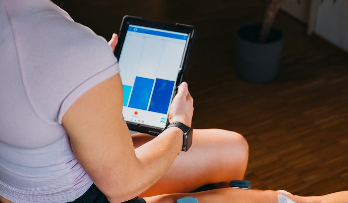 Physikalische Therapie mit EMG bei PhysioSport: Patientin mit Elektroden am Oberschenkel.