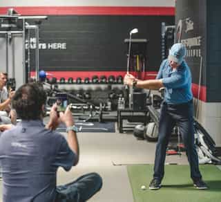 Zu sehen ist ein Golfspieler und ein externer Trainer beim Training mittels TPI-Golfscreening durch PhysioSport Köln zur Verbesserung seiner Leistung.