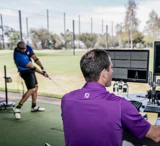 Zu sehen ist ein Golfspieler und ein externer Trainer beim Training auf einer Golfanlage zur Verbesserung seiner Leistung mittels TPI-Golfscreening durch PhysioSport Köln.