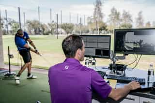 Zu sehen ist ein Golfspieler und ein externer Trainer beim Training auf einer Golfanlage zur Verbesserung seiner Leistung mittels TPI-Golfscreening durch PhysioSport Köln.