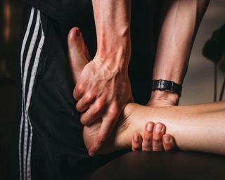 Physiotherapeut von PhysioSport Köln bei Untersuchung der Achillessehne eines Patienten.