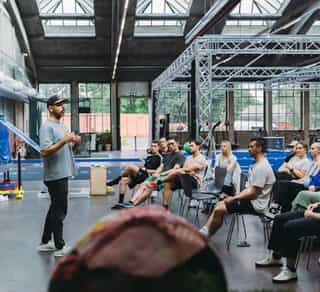 Physiotherapeut von PhysioSport Köln erläutert einer Gruppe von Sportlern bestimmte Trainingsgrundlagen.