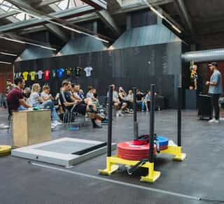 Trainer erläutert diverse Trainingsprinzipen einer Gruppe von Patient:innen in der Trainingshalle von Physiosport Köln.