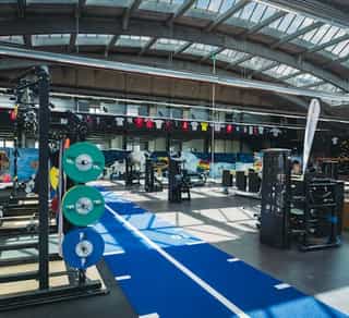 Einblick in die große Trainingshalle von Physiosport Köln mit Geräten und Trainingsstationen.
