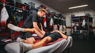 Profisportler auf einer Behandlungsliege wird von einem Physiotherapeuten von Physiosport Köln nach Muskelverletzung behandelt.