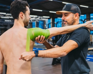 Sportler wird von einem Physiotherapeuten von PhysioSport Köln an der Schulter behandelt nach Schulterluxation.