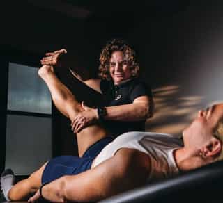 Physiotherapeutin von PhysioSport Köln behandelt eine Patientin mit Krankengymnastik auf neurologischer Basis im Bereich der Beine und Hüfte.
