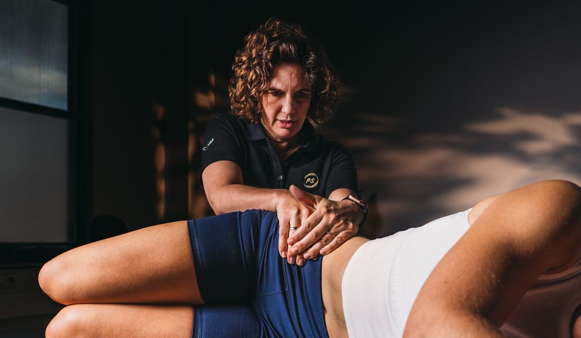 Physiotherapeutin von PhysioSport Köln behandelt eine Patientin mit Krankengymnastik auf neurologischer Basis im Rumpfbereich.