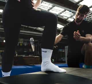 Sportlerin bei PhysioSport Köln mit Therapeut während Übungen im Bereich Neuroathletik Training.