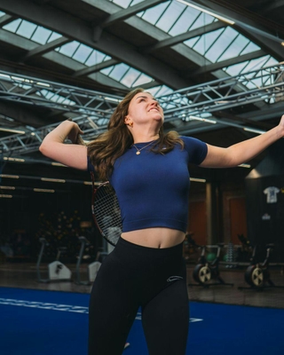 Sportlerin während Tennisübungen bei PhysioSport Köln nach Schulterbeschwerden.